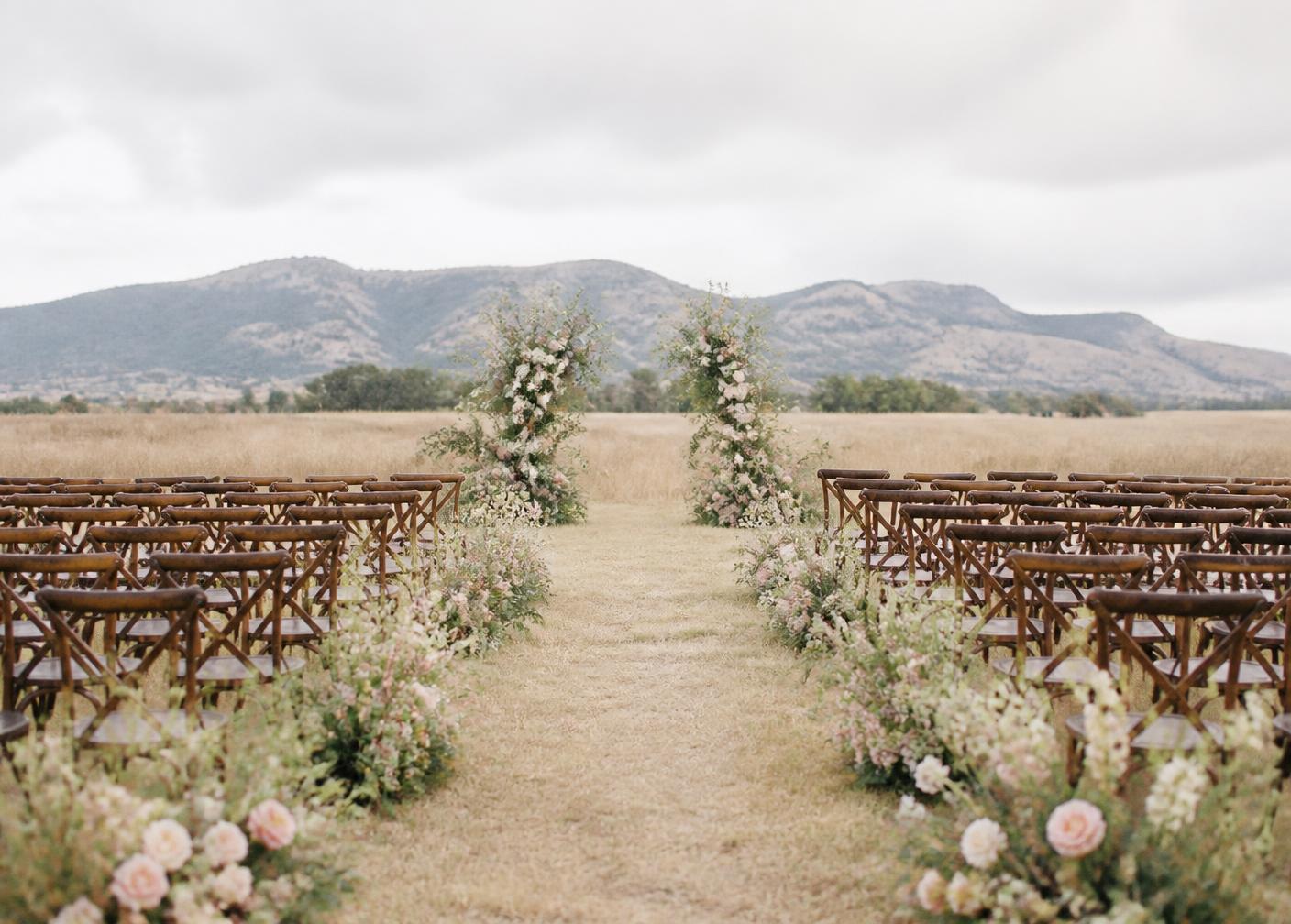 Lush ceremony florals in cream, blush and sage